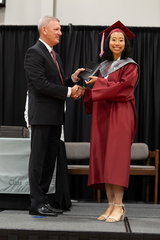 Board Chairman Stephen Chambers presents diploma to Jasmine David.